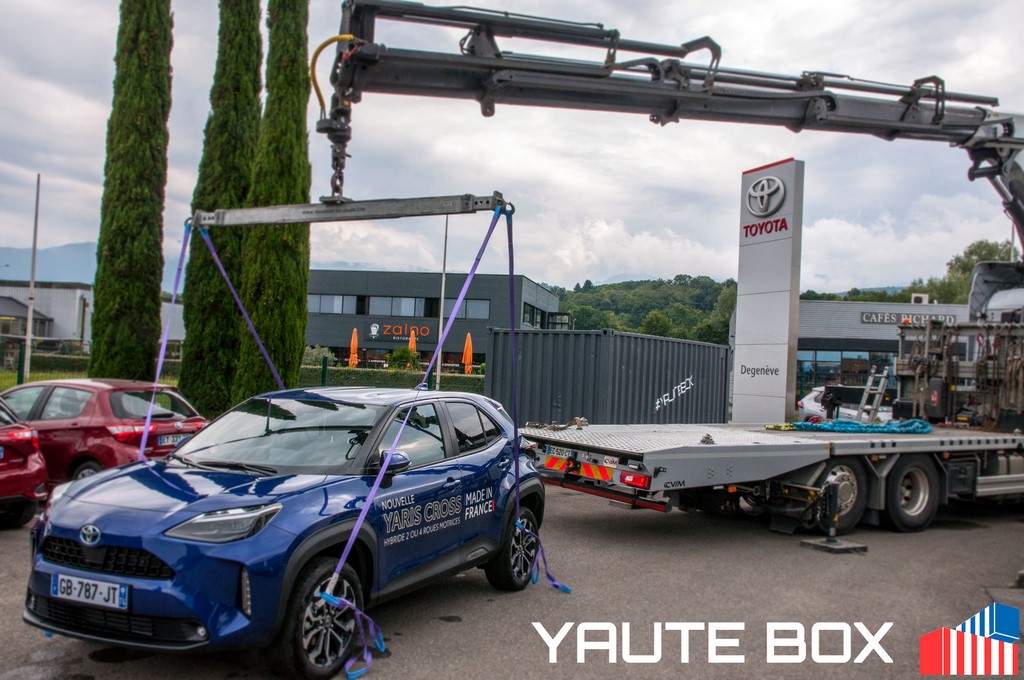 levage du toyota yaris voiture avec un camion grue pour installation sur container dans le fond